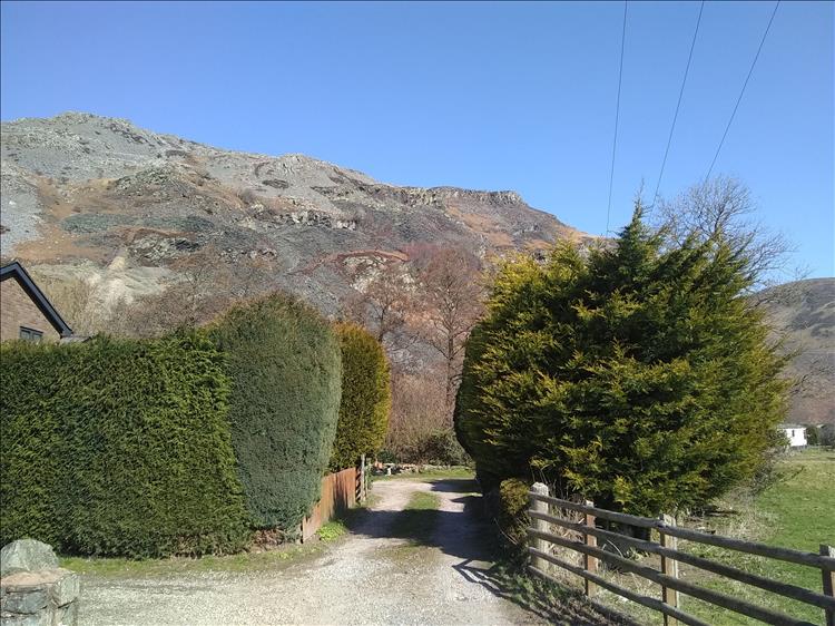 A rocky bulbous hill dominates the backdrop of the view from the pub