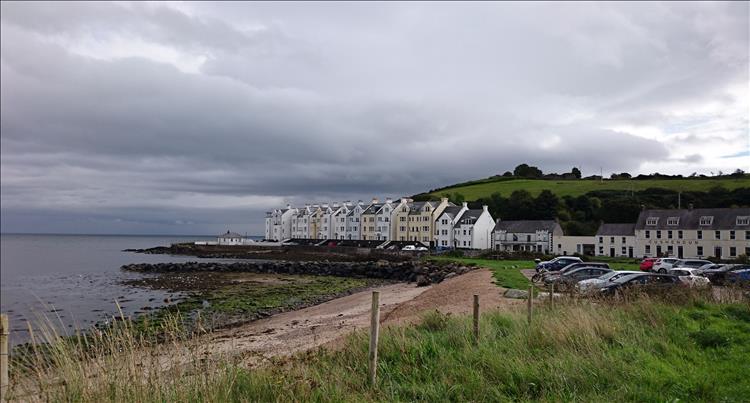 The wall into the sea has houses and a run down hotel on it at Cushendun