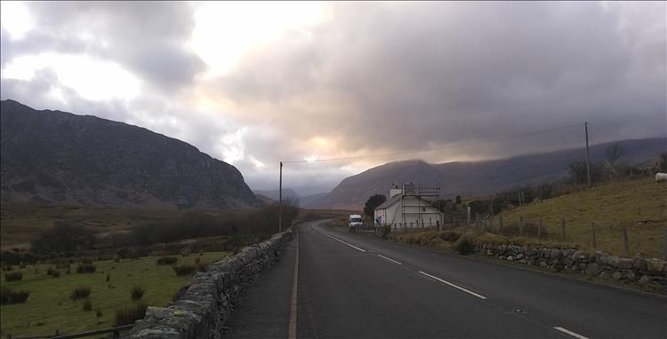 Bulbous rocky mountains, ominous skies and a lonesome house by the road 