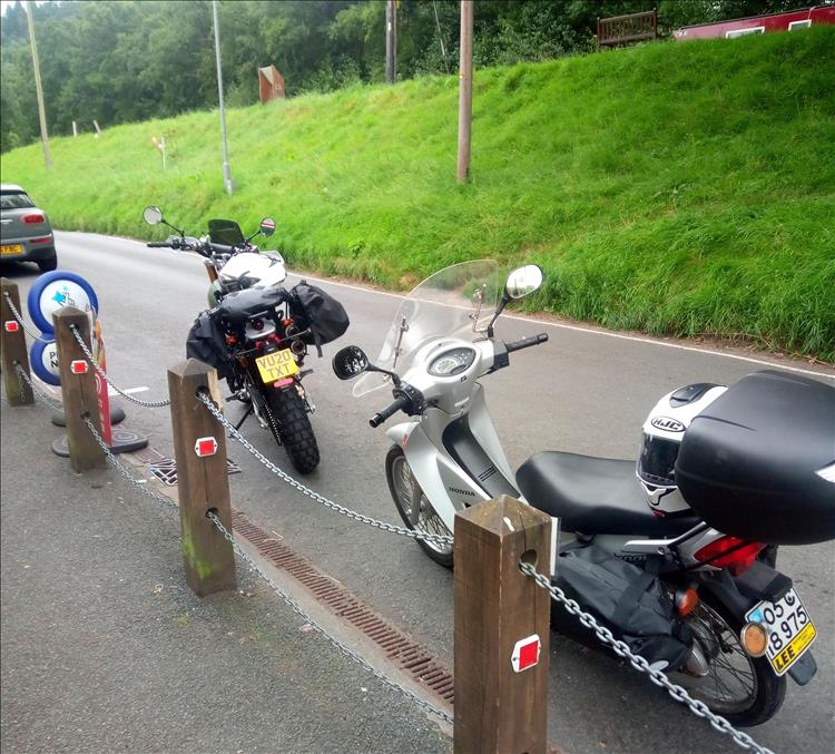 The Innova and the rear of the Fantic with luggage outside the cafe