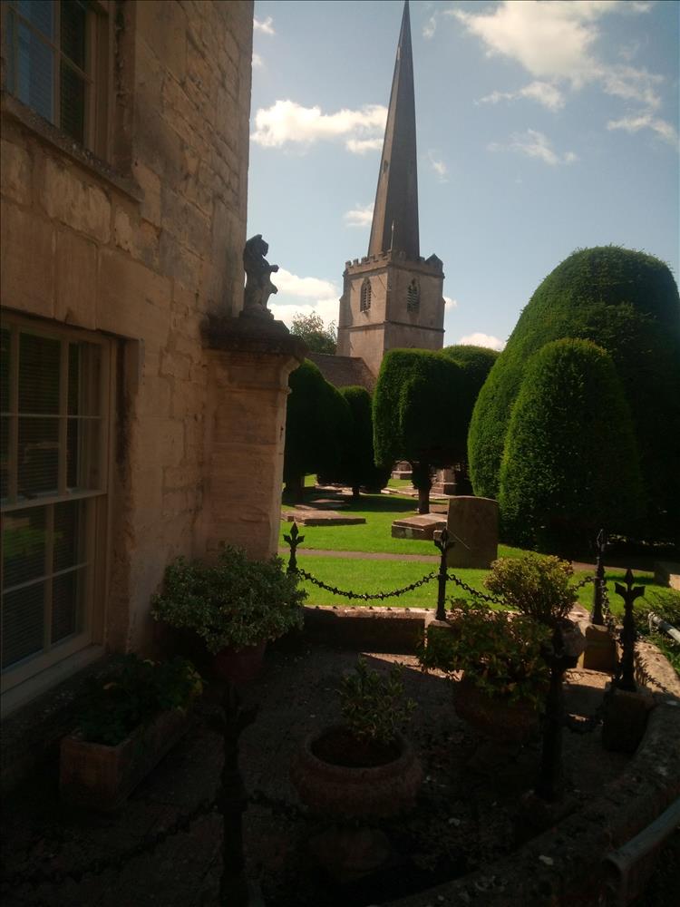 The pointy spired church and manicured lawns in Painswick