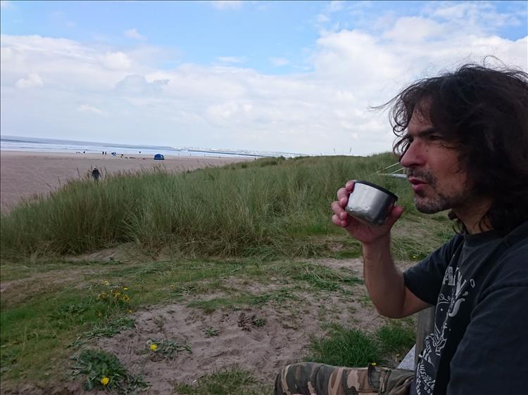Ren sips tea while looking out to sea over the sands of Castlerock beach