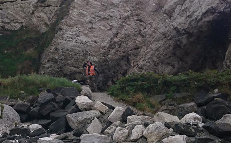 Ren makes a silly man of action pose on the rocks at Ballintoy