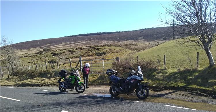 Sharon holds her phone in the splendid welsh scenery