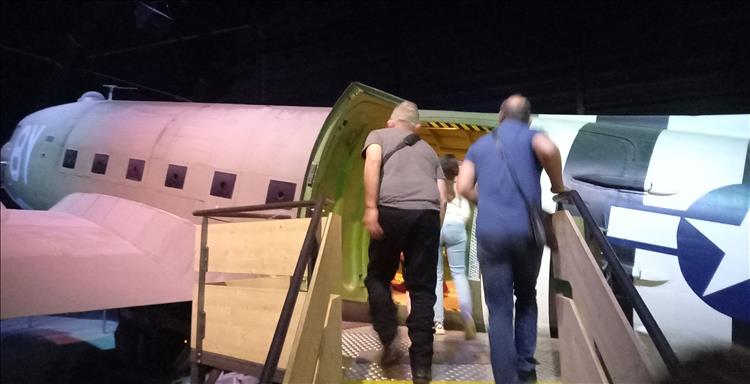 Going up the stairs into a WW2 airplane in a hanger