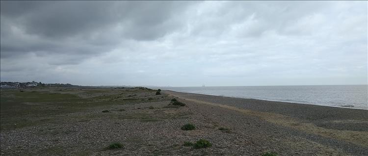 Very heavy skies, a vast broad stony beach and a murky sea at Kessingland
