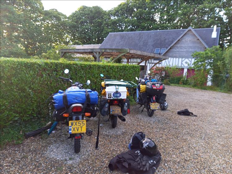 Behind the 3 small bikes there's a large French house