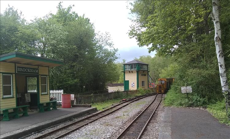 Narrow gauge lines and the front of a very small train coming along the line