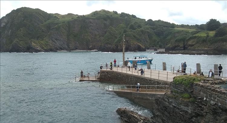 A modern harbour wall, steep cliff across the other side of the bay at Ilfracombe