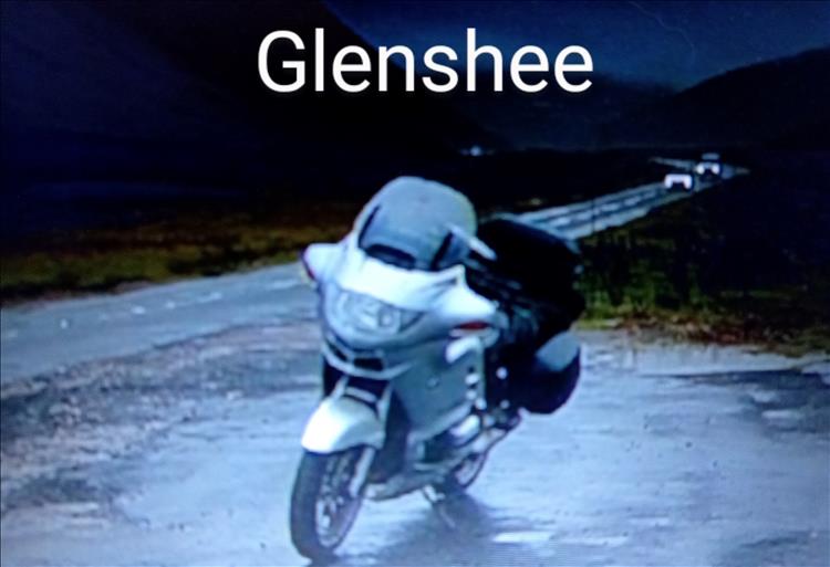 A grainy dark image of ROD's big touring BMW on a bleak road across the mountains