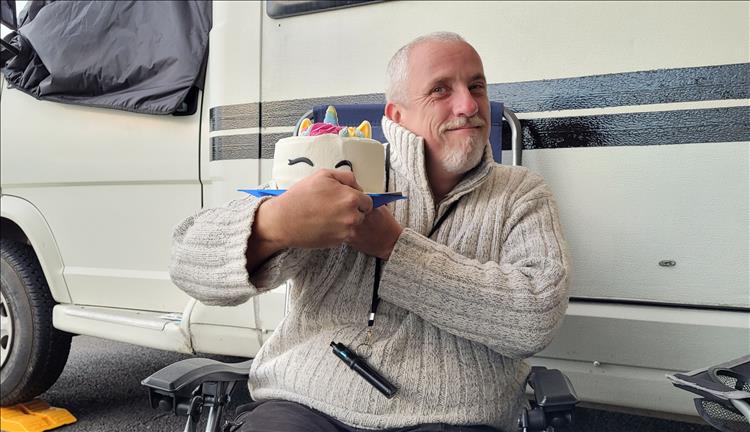 Rik holds his little child's cake and smiles