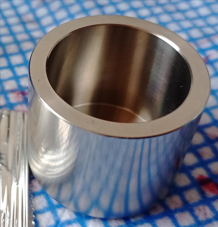 A round, small stainless steel brake piston
