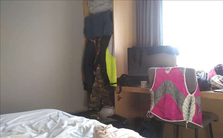 The room is filled with bike gear and clothing, little room for much else