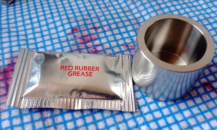 THe new piston and a sachet of red grease