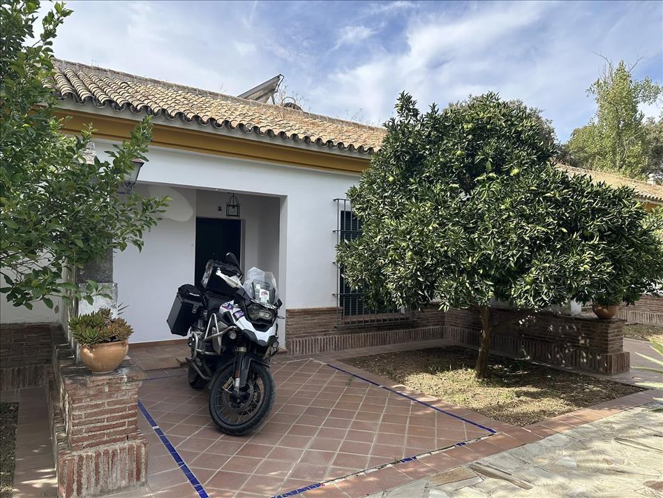 A bungalow, a room for the night with Andy's BMW parked outside the door on a tile patio