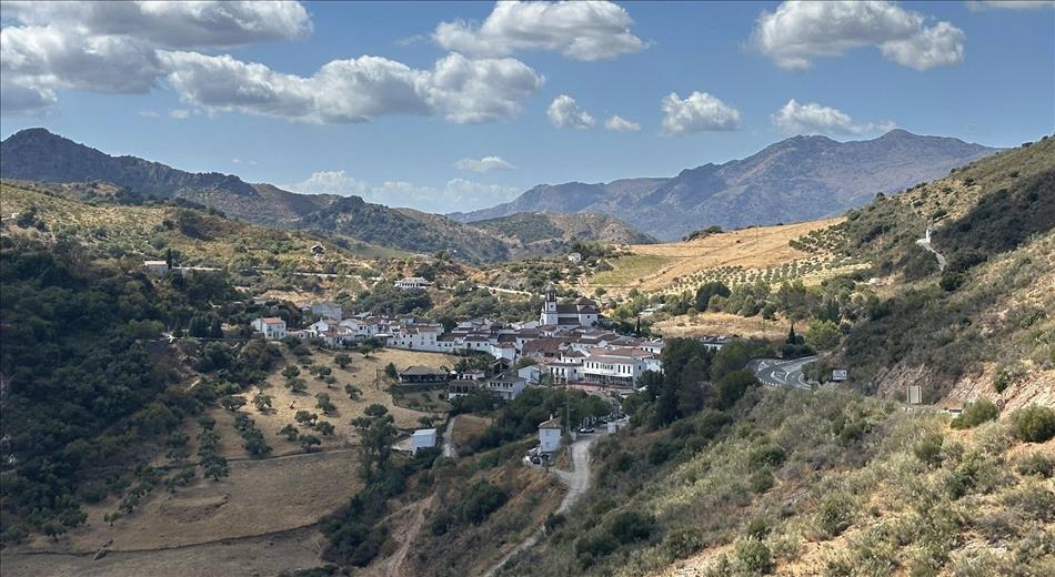 A small white painted spanish town nestled in the valley among the mountains