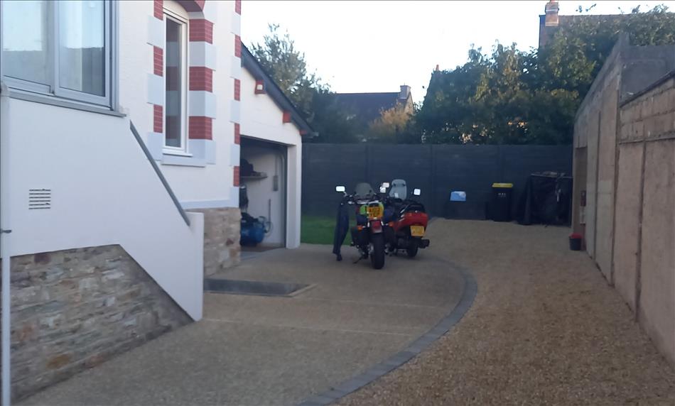 2 motorcycles outside a smart garage on the driveway in the early morning