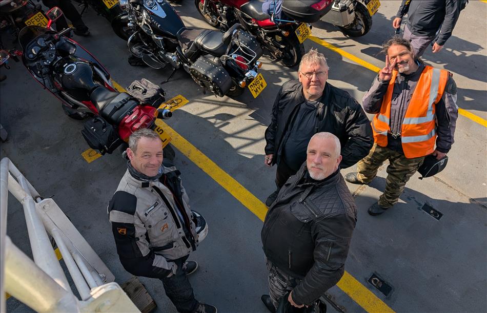 4 lads in bike gear beside the bikes on a ferry to Arran