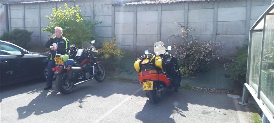 Bogger's pal eating a snack stood by his Honda Shadow, and bogger's Majesty scooter