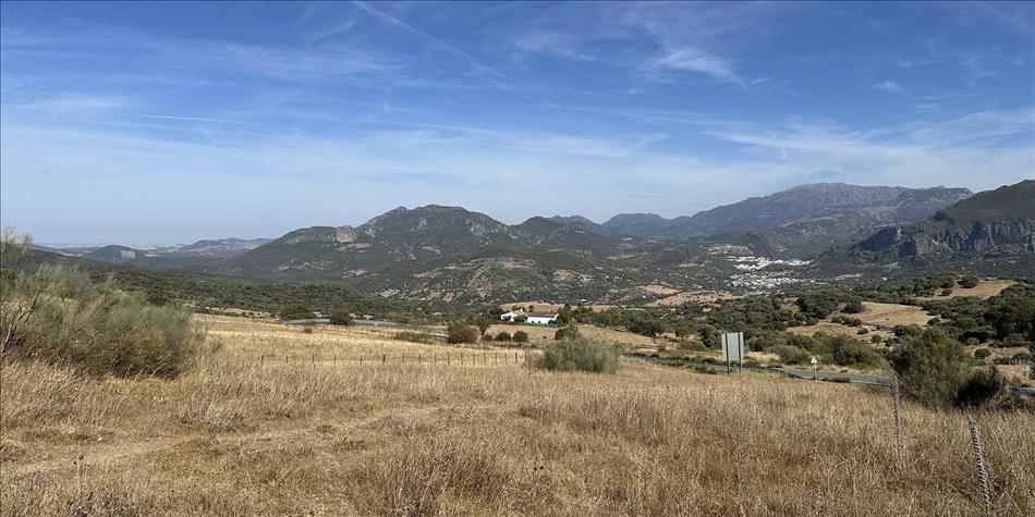 dry grass, hills into the distance, we can make out a town in the folds of landscape away in the distance