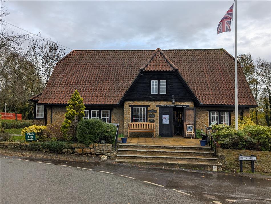 A large old building, maybe 1700s in stone and steep roof, pretty and local town hall