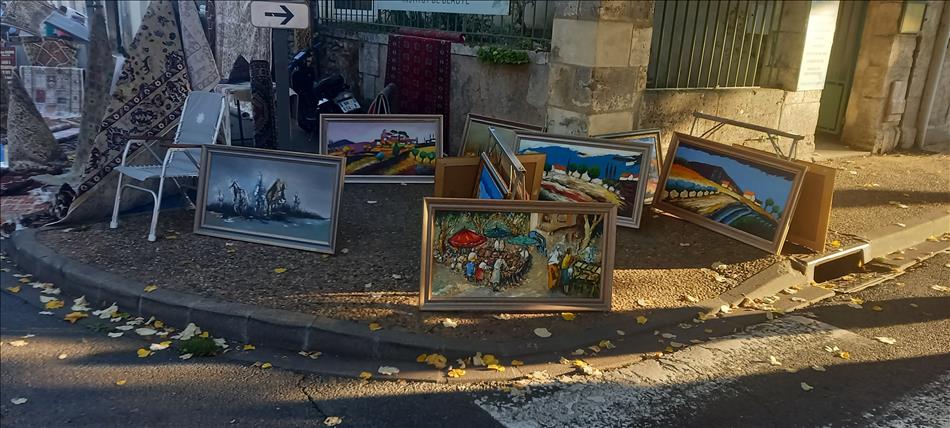 a selection of painting just placed on the pavement ready to sell at the market
