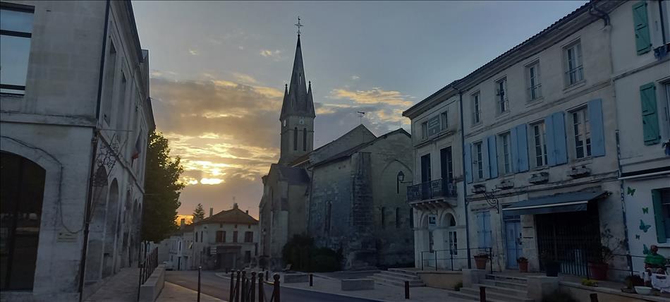 Stone buildings dominated by a church with spire in a typically french town