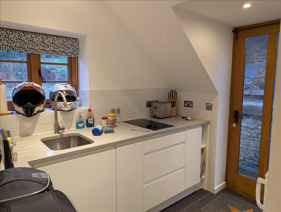 A small corner of the studio with a tiny kitchen with sink and stove as you'd expect. Clean and fresh