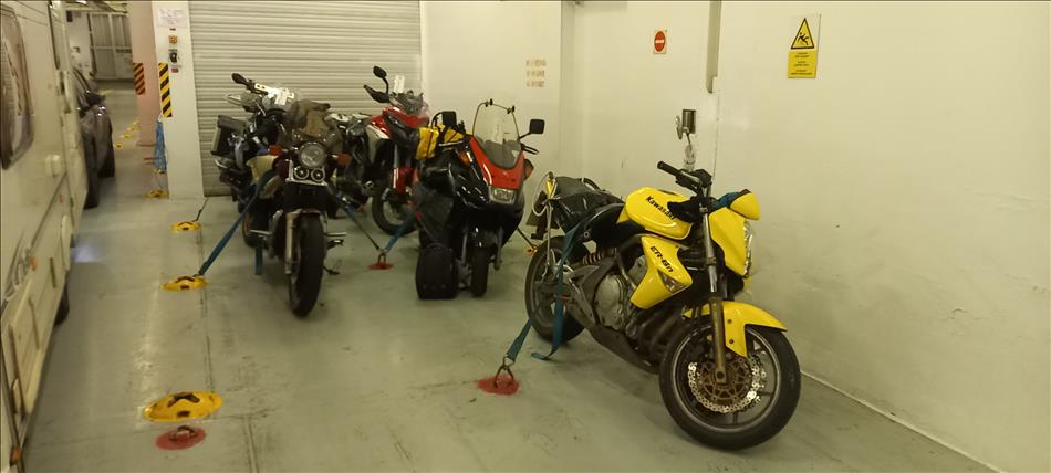 5 motorcycles strapped down in a corner of the ferry's car deck