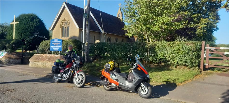 Pete with his Shadow 750 and Boggers Majesty 250 beside a church in the English countryside
