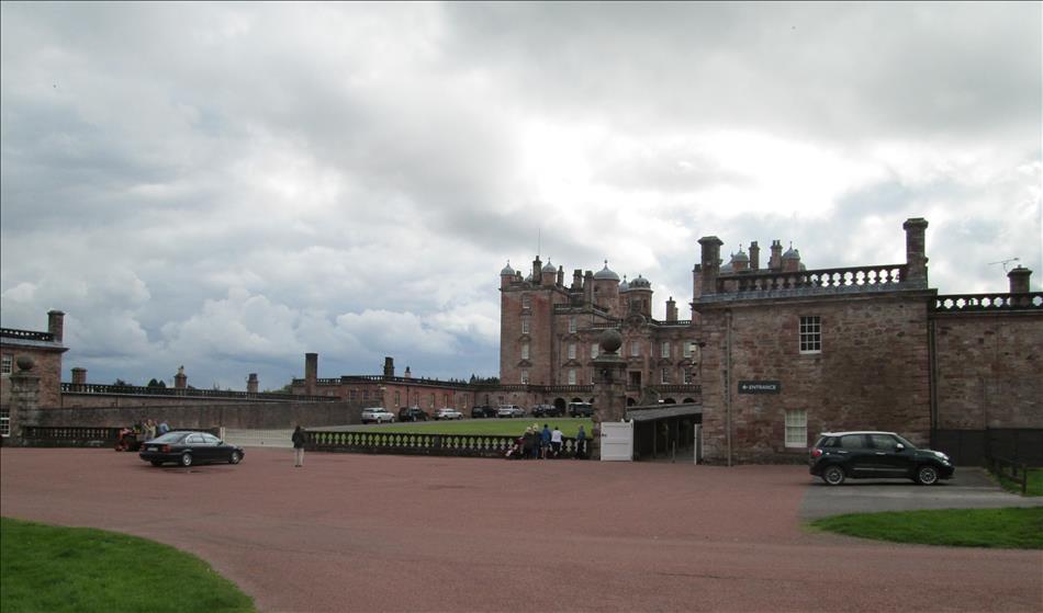 The large stately home is enormous with gardens and driveways and many buildings