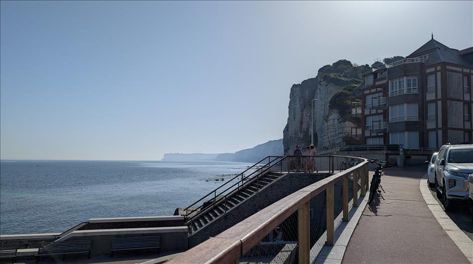 Sea defences, the stoney beach, white cliffs and more cliffs in the hazy distance