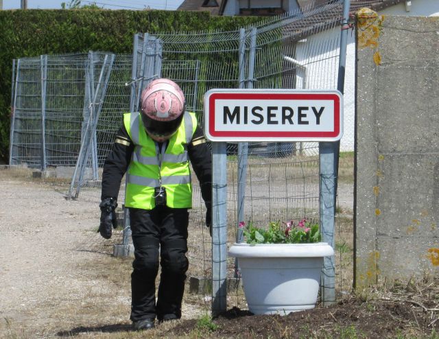 Sharon stands head bowed by the town name of "Miserey" in France