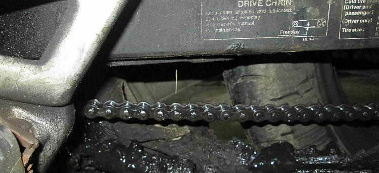 A very lubricated chain among lots of thick greasy dirt and oil