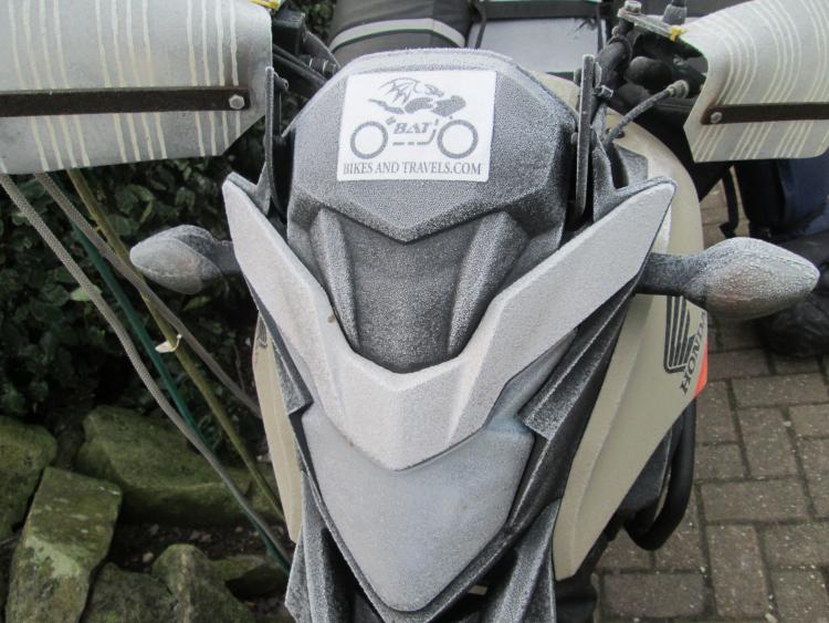 A thick layer of frost covers the headlight and fairings on the CB500X