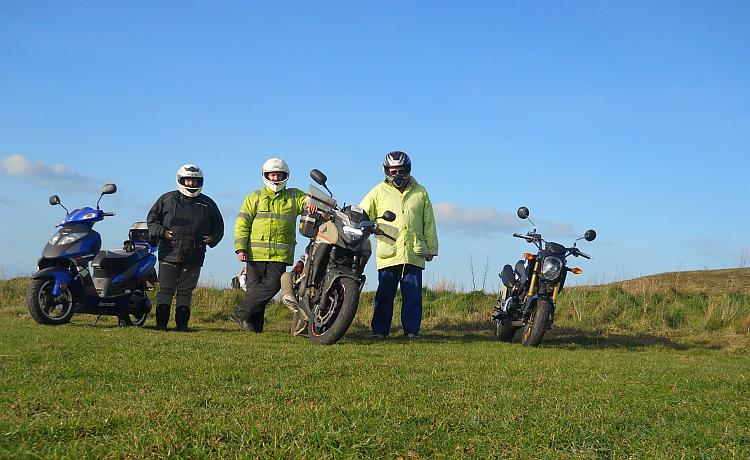 Mark Nina and Ren stand beside their motorcycles at Godrevy