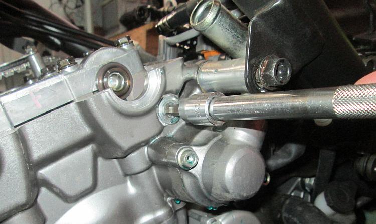 The bolt that must be removed to allow removal of the pin