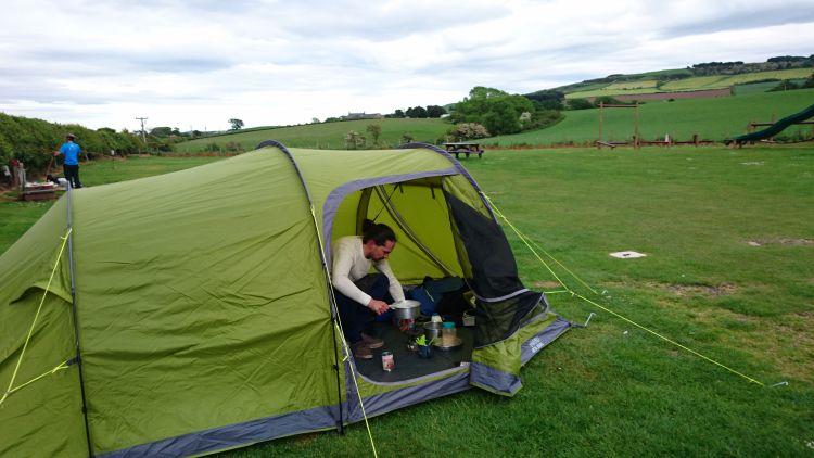 Ren can be seen cooking on the stove in the entrance to the tent